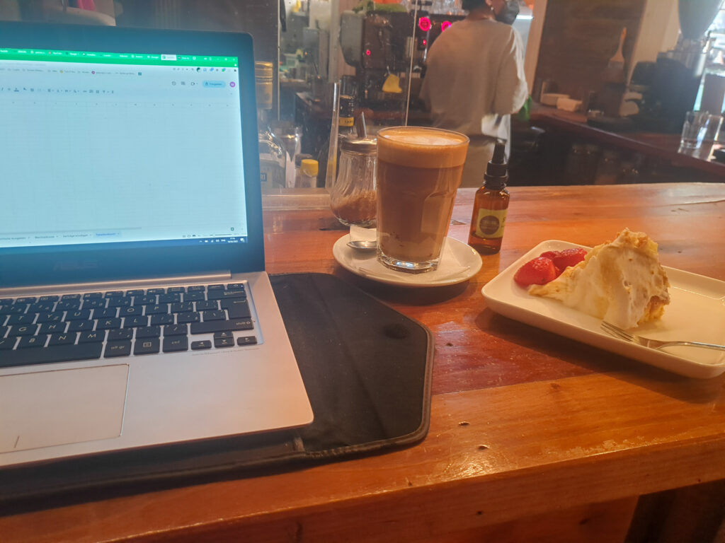 Laptop with a coffee mokka and 3 leches cake.